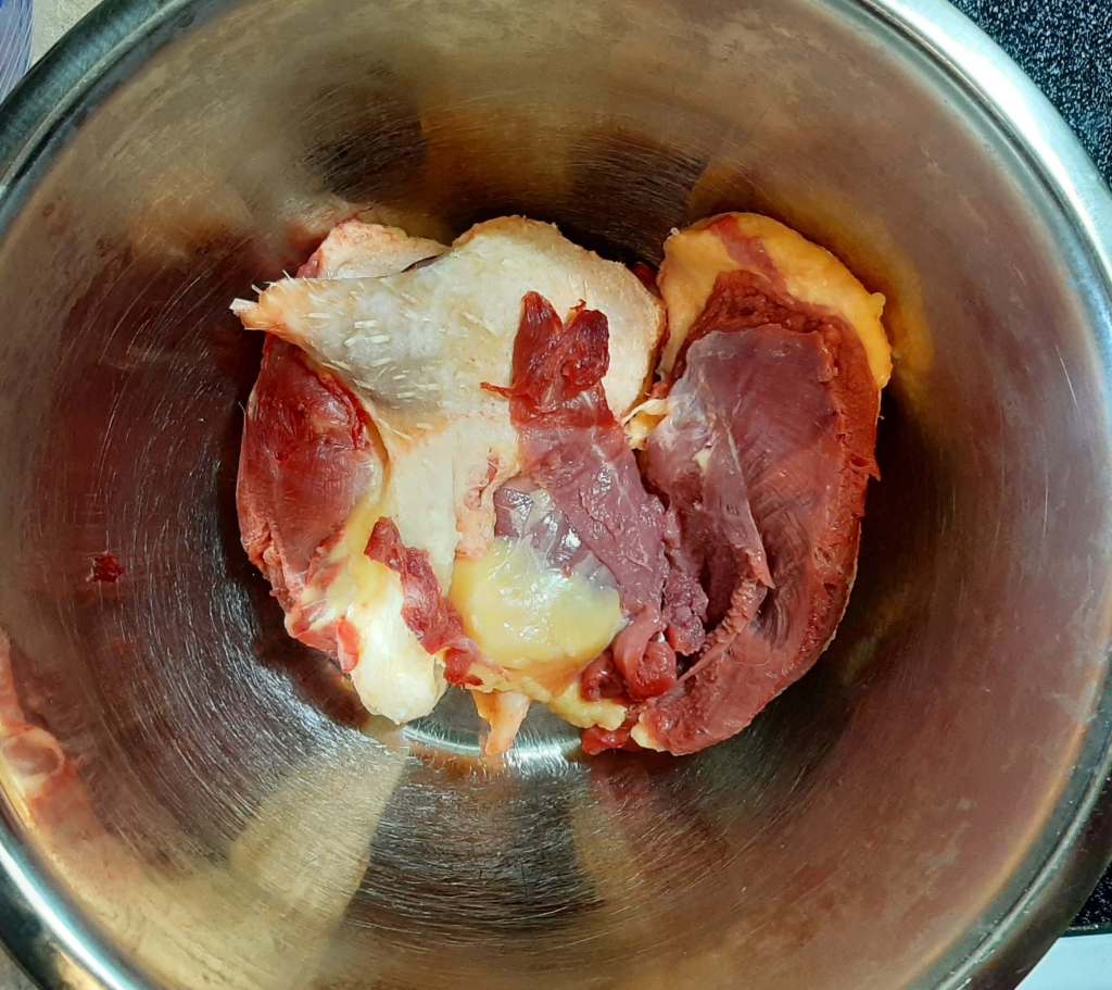 Raw meat in a stainless steel bowl