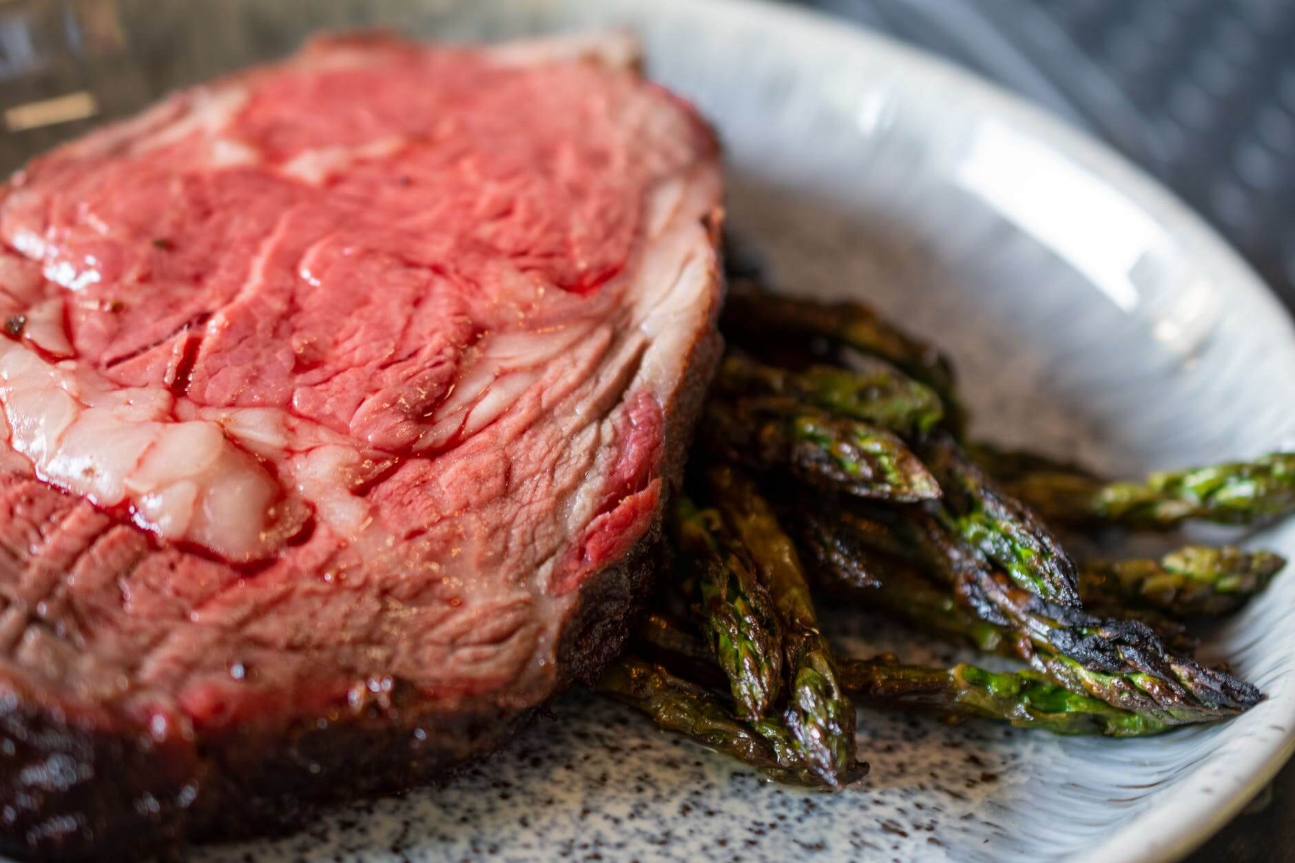 sliced meat on stainless steel plate with asparagus