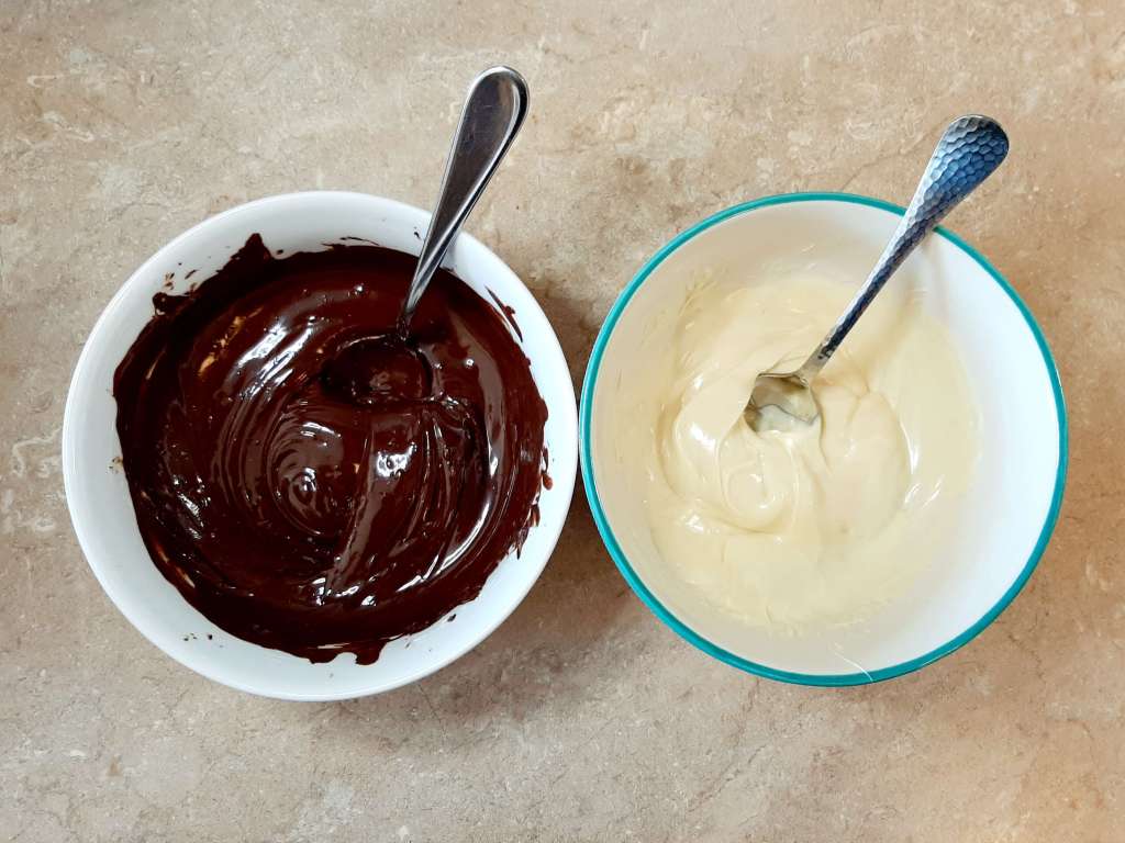 melted chocolate and melted vanilla in 2 white bowls