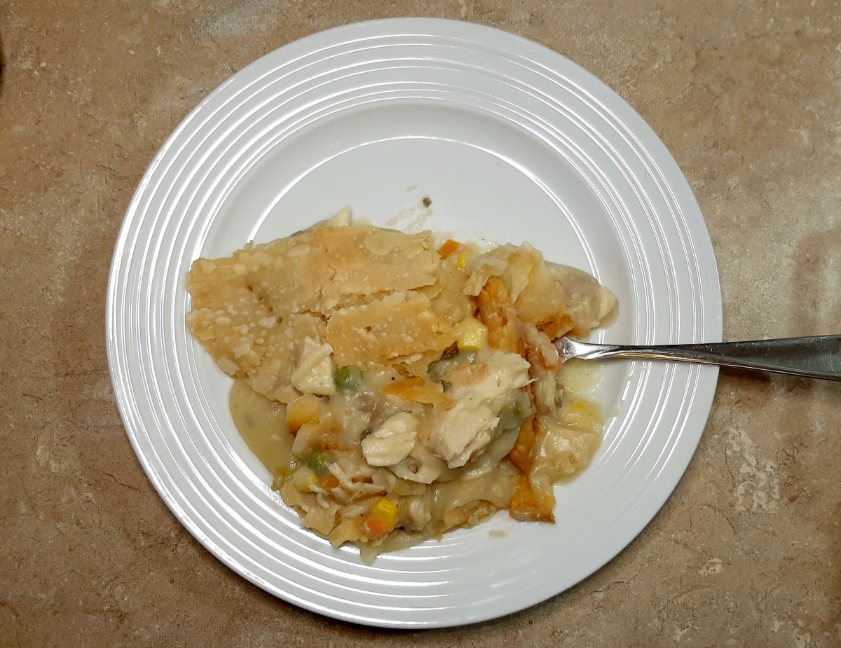 turkey pot pie casserole on a white plate with a fork