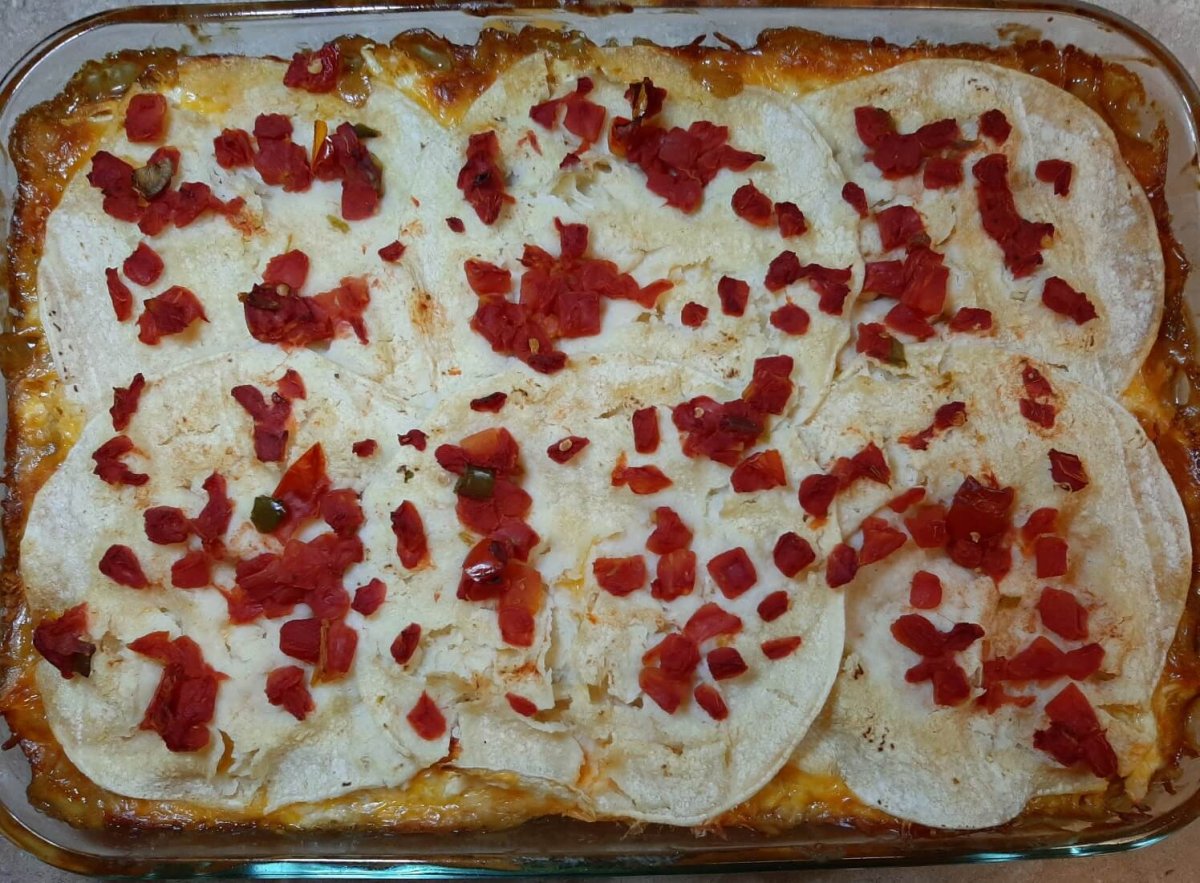 King Ranch chicken casserole with layer of tortillas and tomatoes