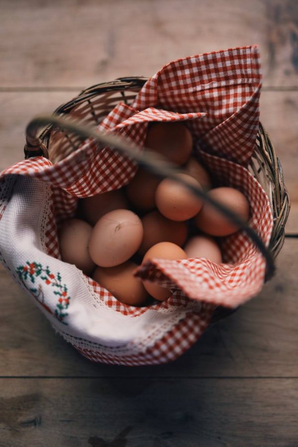 chicken eggs placed in wicker basket on table