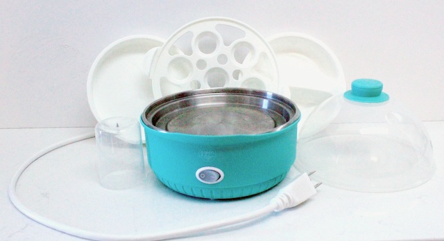 multiple parts of white and turquoise small kitchen appliance on white background