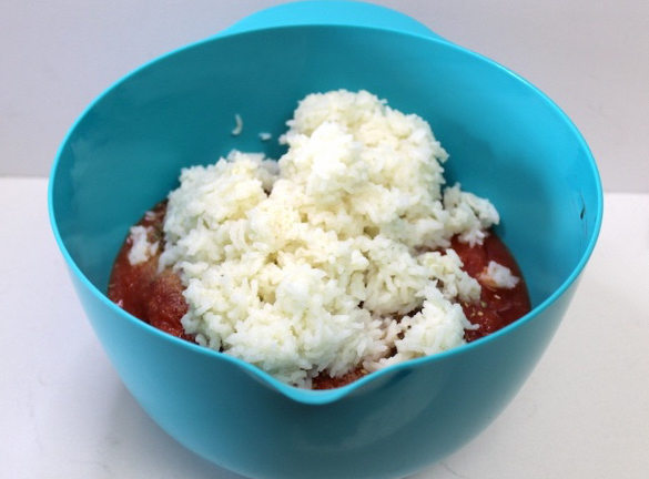 rice and tomato sauce in a blue bowl on a white background